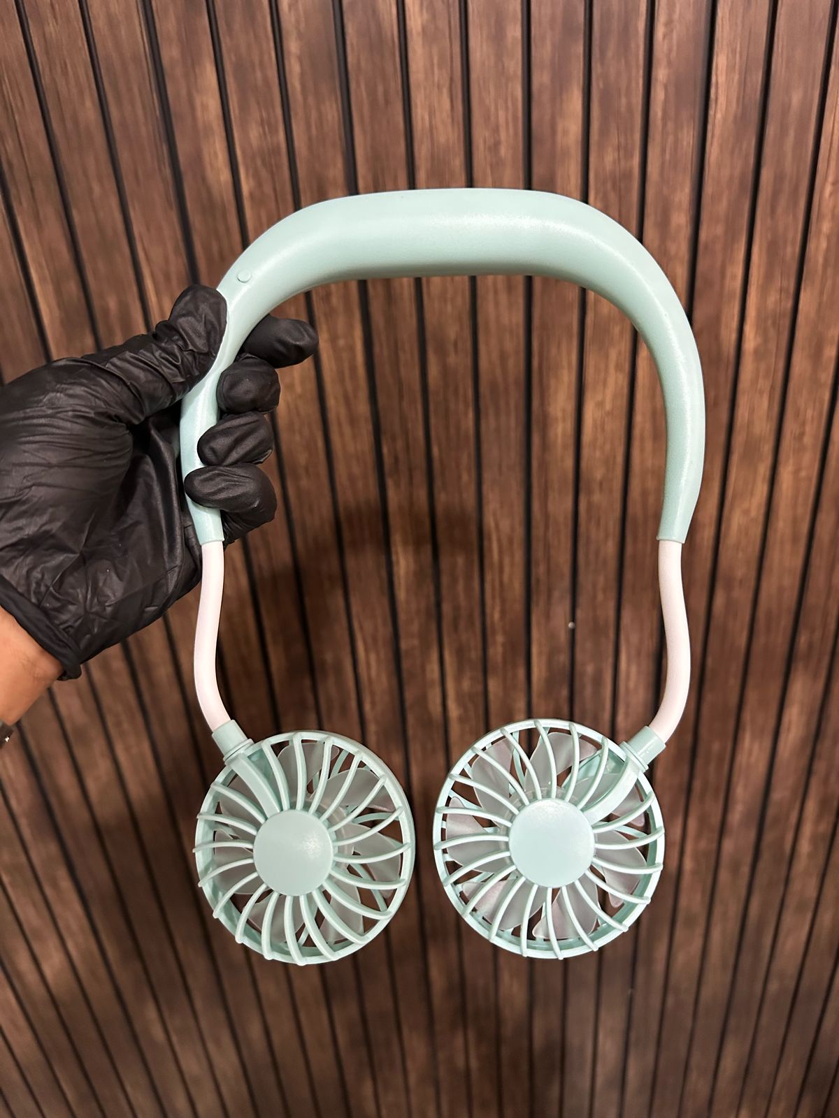 Handheld fan with two circular fans on a wooden background