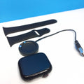 Smartwatch with charging stand, cable, and strap on a white surface with blue background