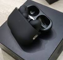 Black wireless earbuds in a charging case on a white background