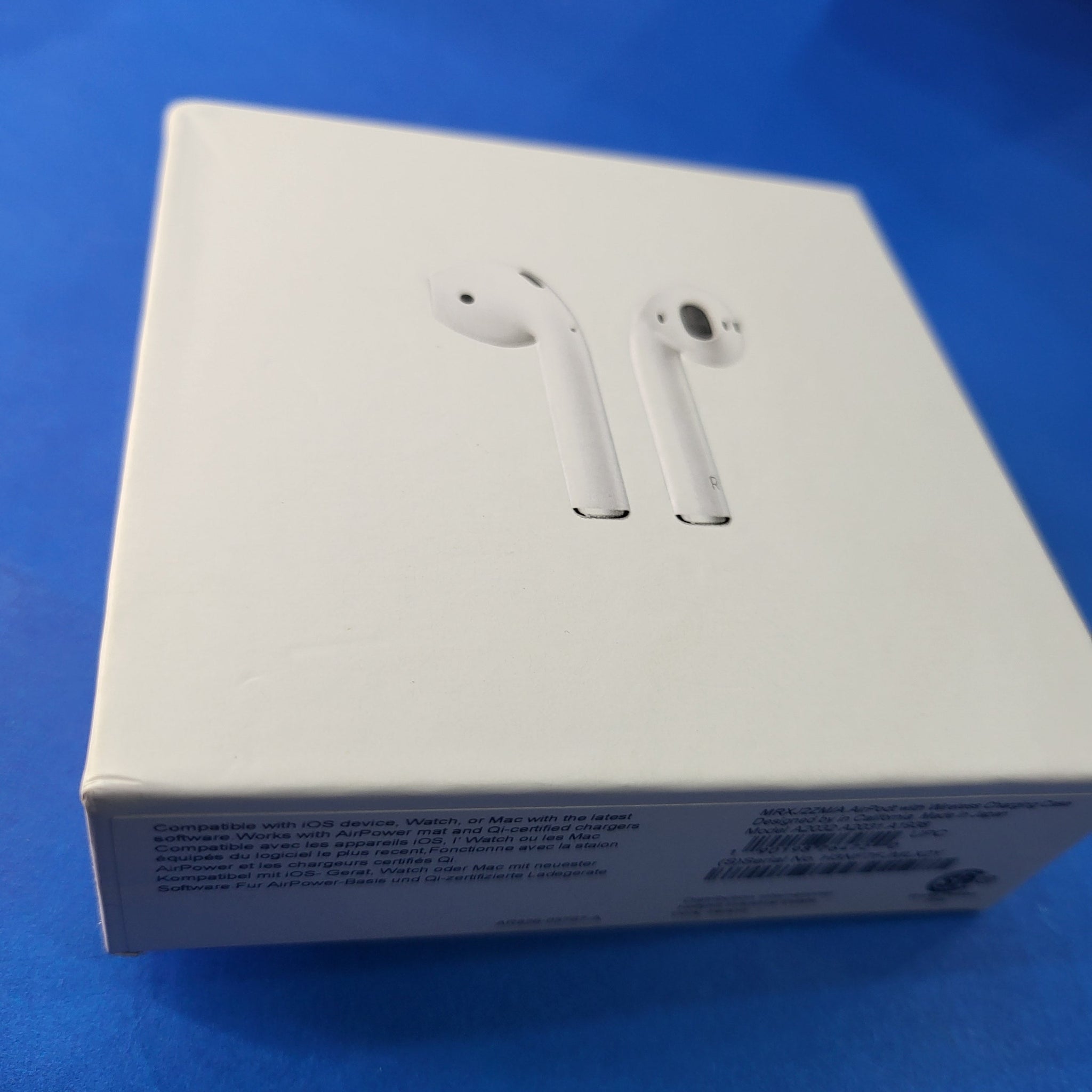 White earbuds on a white box with blue background